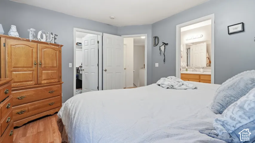 Bedroom featuring wood-finish flooring, light gray walls, and white trim