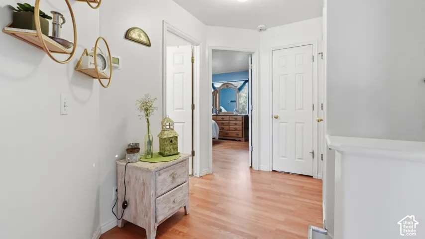 Hardwood-style flooring extends through a bright hallway featuring white walls and white paneled doors