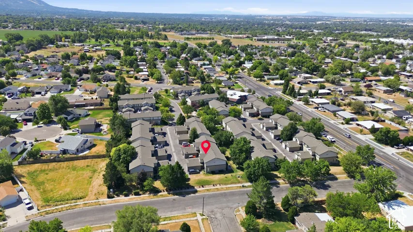 Aerial view showcasing this residential property situated in an established neighborhood with mature tree-lined streets, single-family homes, and expansive green spaces