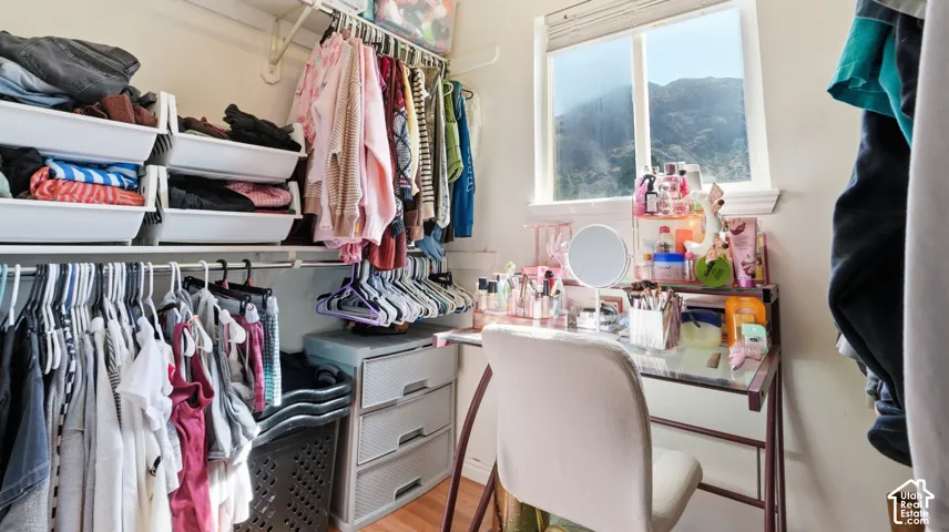Custom closet system featuring multiple hanging rods, open shelving, and a built-in window with mountain scenery