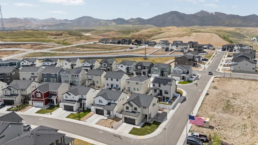 Contemporary residential development featuring a variety of architectural styles, paved roadways, and mountain backdrops