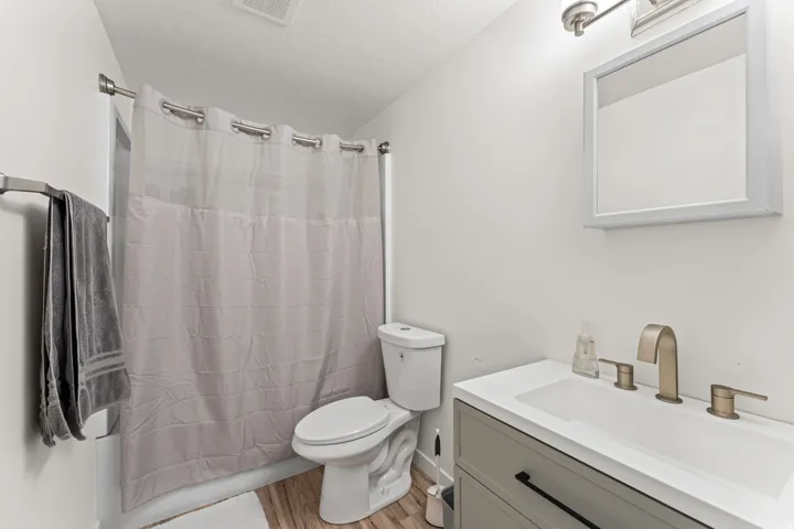 Bathroom featuring a vanity with an integrated sink, brushed nickel faucet, and a wall-mounted mirror