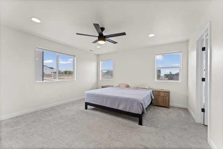 Spacious interior with neutral carpeting and a contemporary ceiling fan