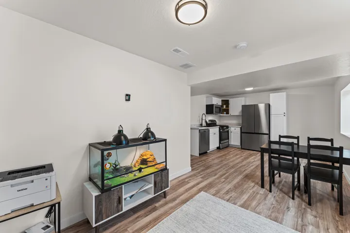 Open-concept living space featuring wood-finish flooring, recessed lighting, and a contemporary flush-mount ceiling fixture
