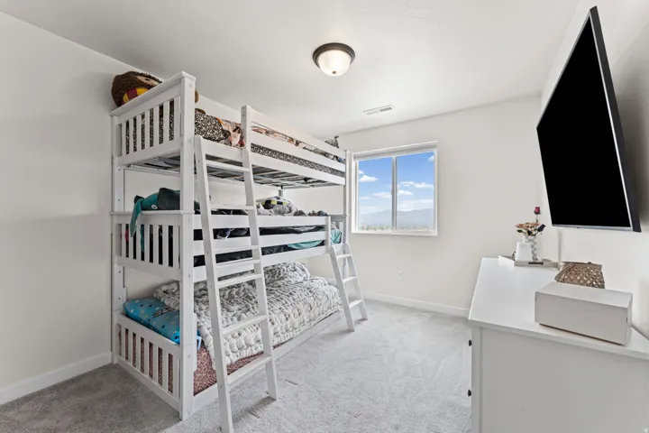 Bright room with light gray carpet, recessed lighting, and a double-paned window providing natural illumination