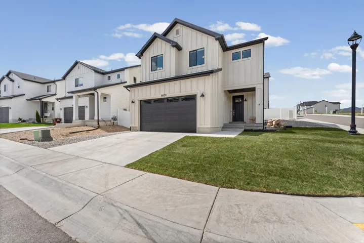 Contemporary two-story residence featuring a two-car garage, board and batten siding, and a covered entry