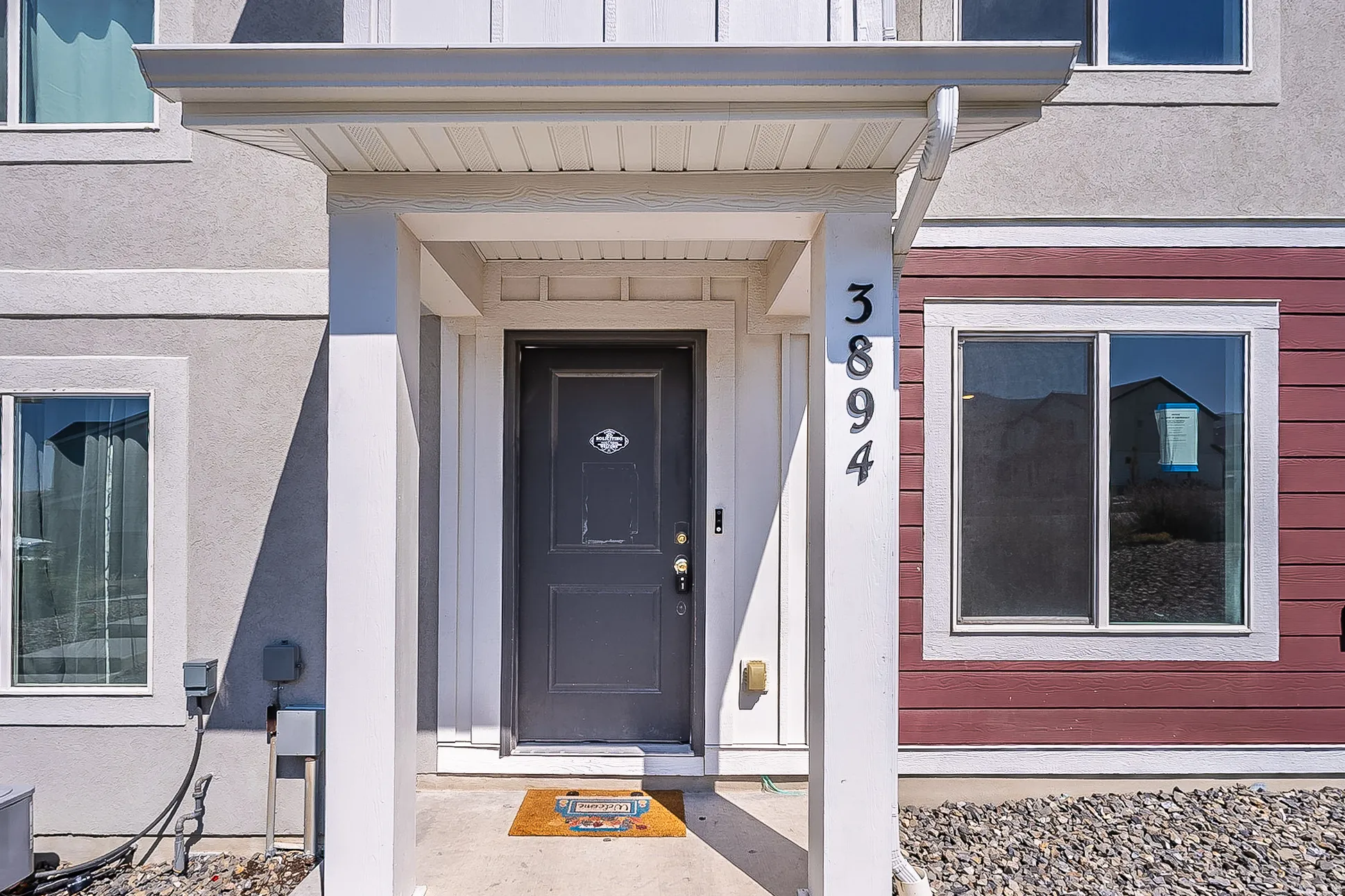 Covered entry featuring a dark-paneled door with house numbers 3894