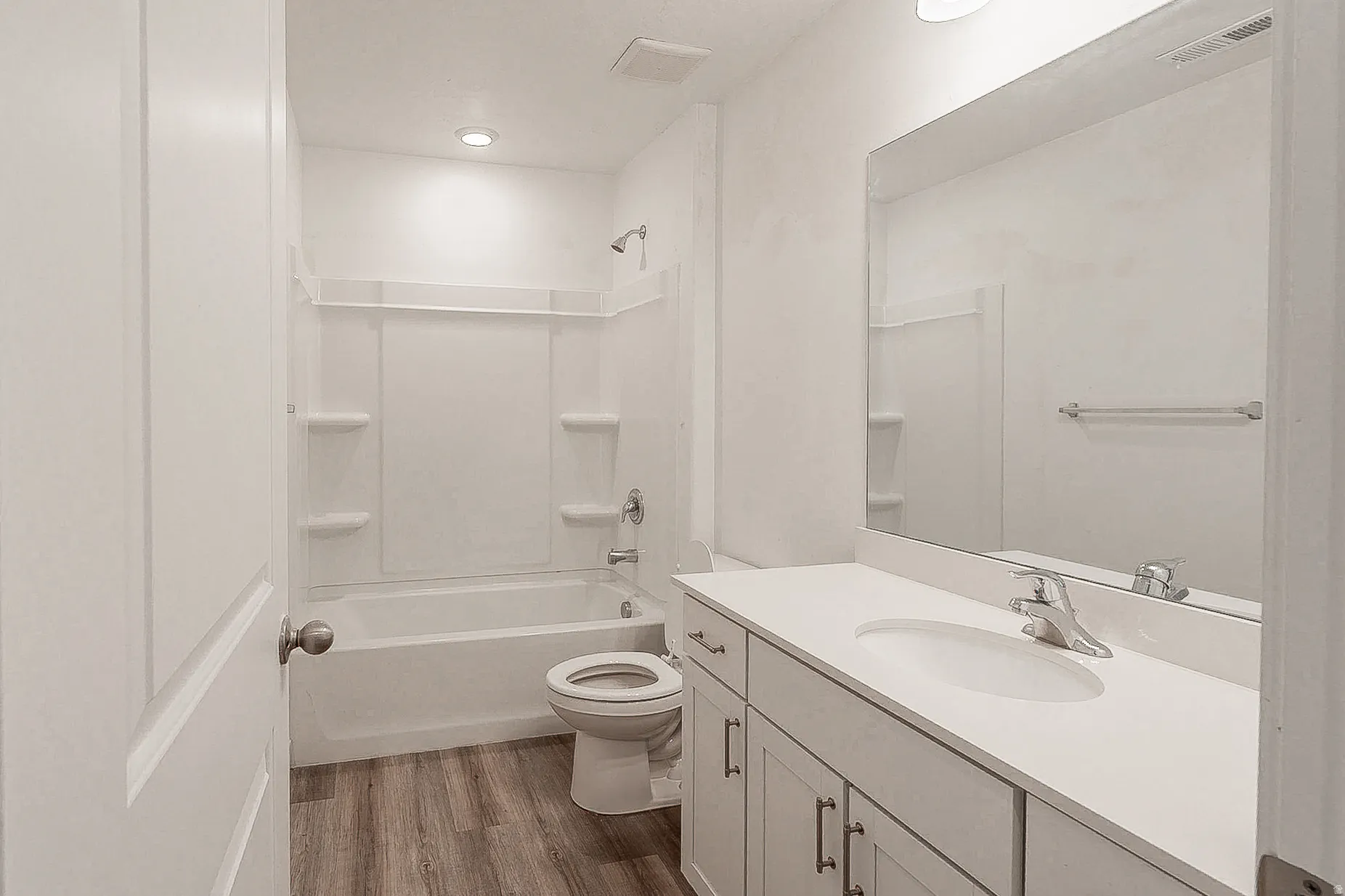 Spa-inspired bathroom featuring a clean-lined vanity with white quartz countertop, brushed nickel faucet, and ample storage cabinetry
