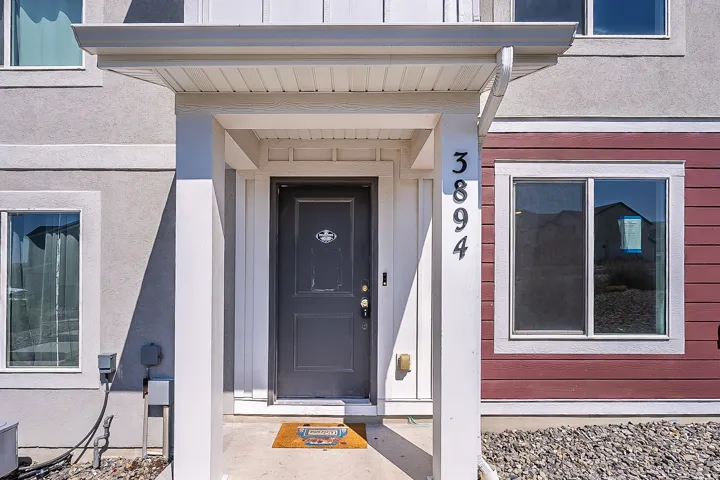 Covered entry featuring a dark-paneled door with house numbers 3894