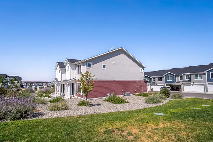 Two-story property featuring light gray stucco and red siding