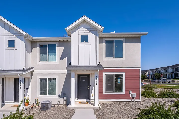 Modern two-story residence featuring a striking mixed-material exterior with white vertical siding, soft taupe accents, and bold red panel detailing