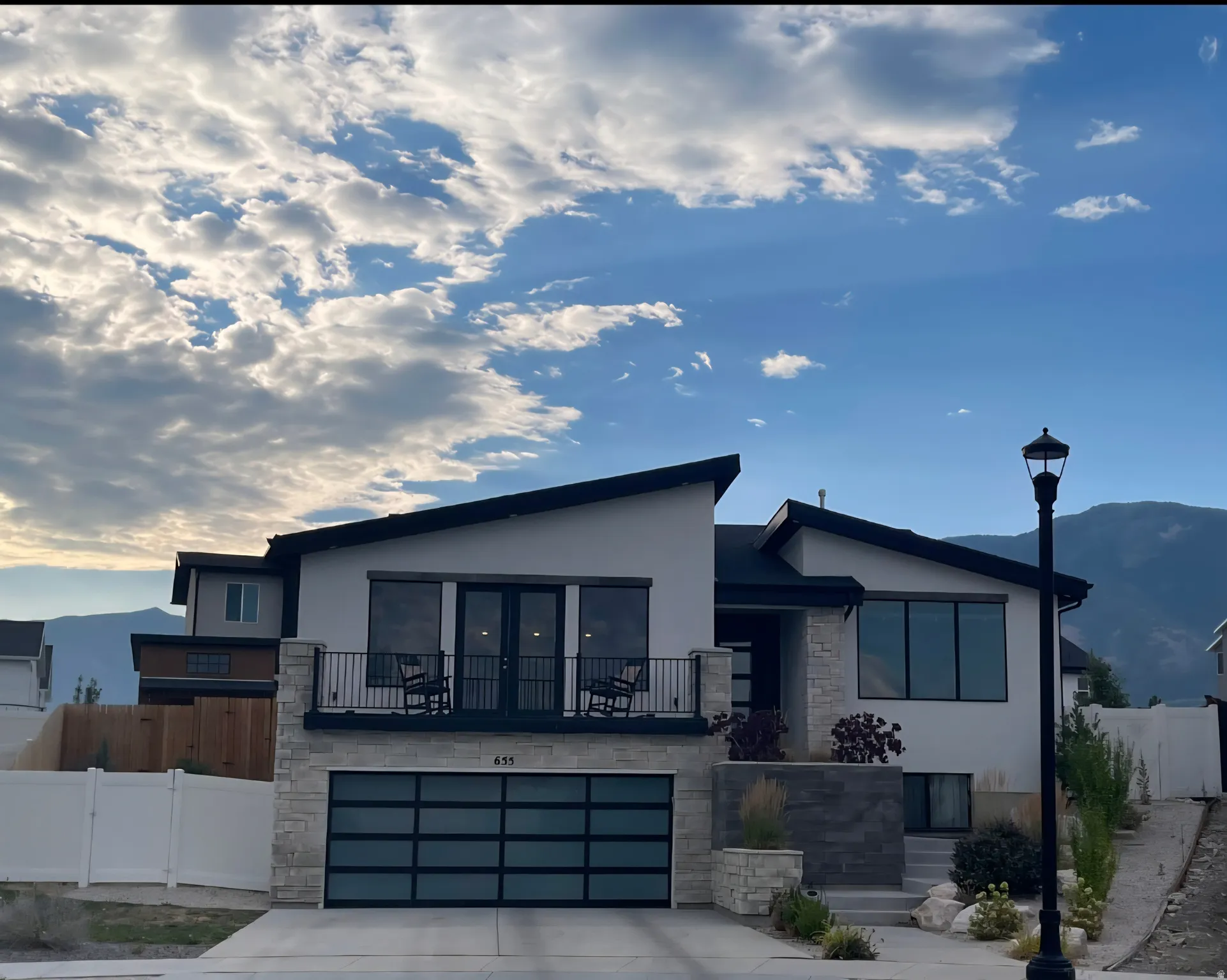Contemporary residence featuring a white stucco exterior with stone accents