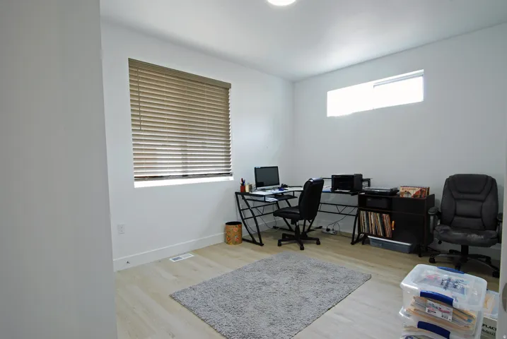 Recessed ceiling lighting, wood-finish flooring, and multiple windows with blinds