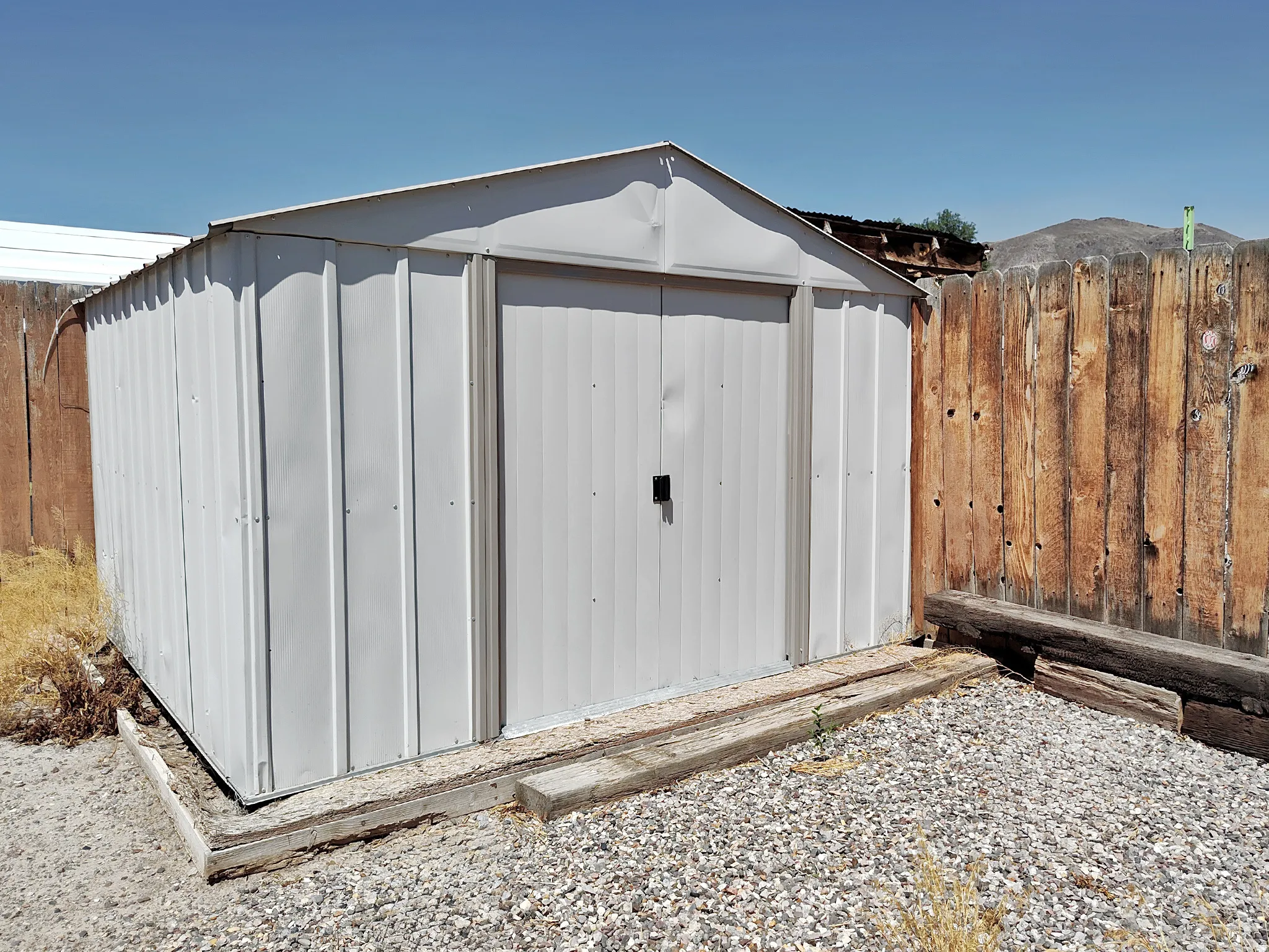 Metal storage shed with a peaked roof and double doors