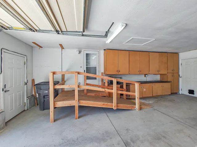 Garage featuring extensive cabinetry, countertop workspace, and concrete flooring