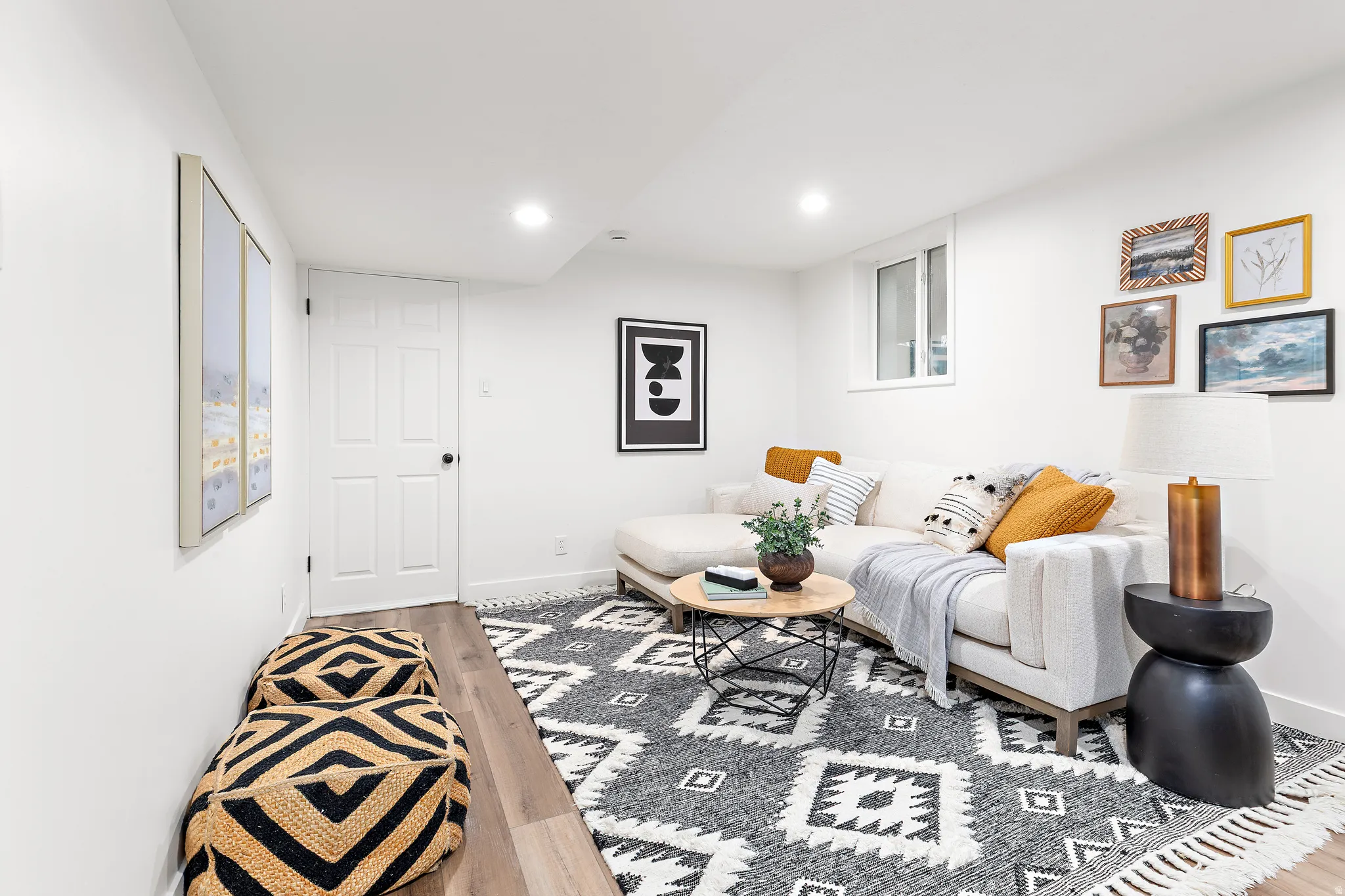 Recessed lighting illuminating a spacious room with light wood-finish flooring