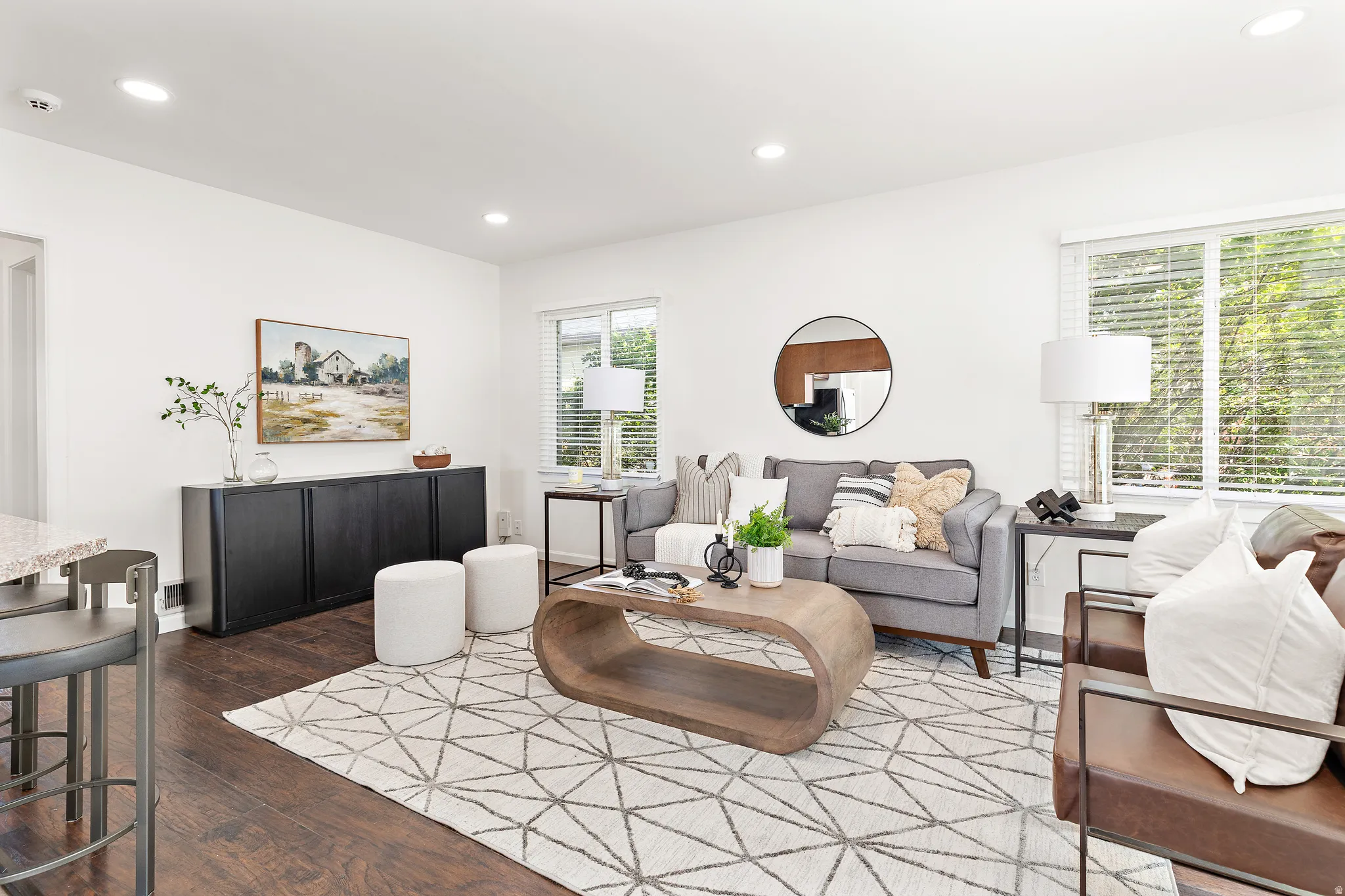 Bright living space featuring white walls and dark wood-finish flooring