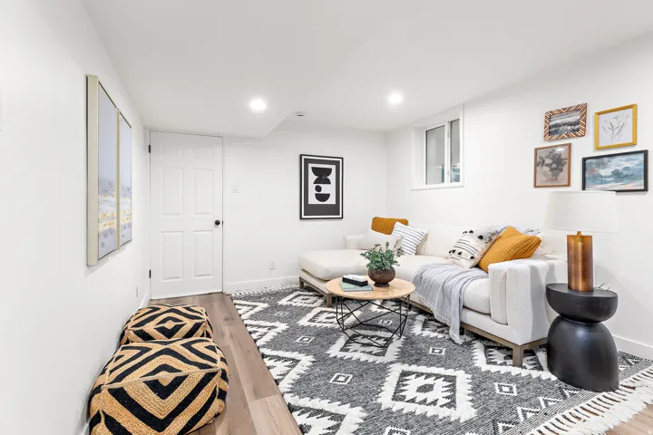 Recessed lighting illuminating a spacious room with light wood-finish flooring