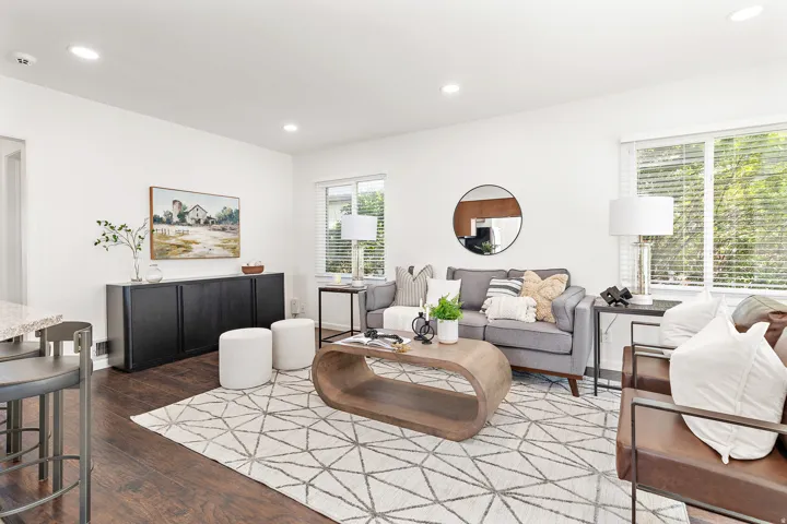 Bright living space featuring white walls and dark wood-finish flooring