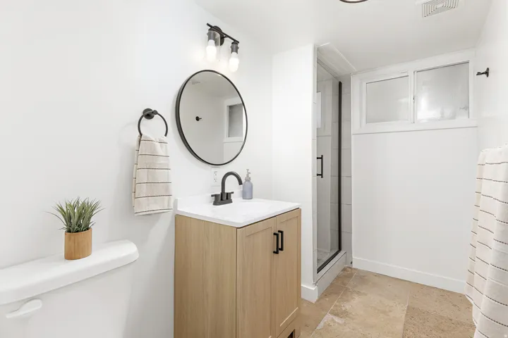 Light wood-finish vanity with a white countertop and matte black hardware