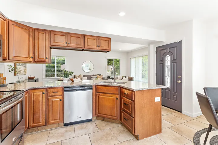 Kitchen featuring wood cabinetry, light-toned countertops, and stainless steel appliances