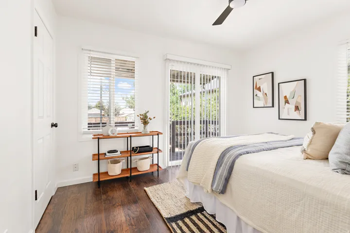 Bright room featuring wood-finish flooring, white walls, and a contemporary ceiling fan