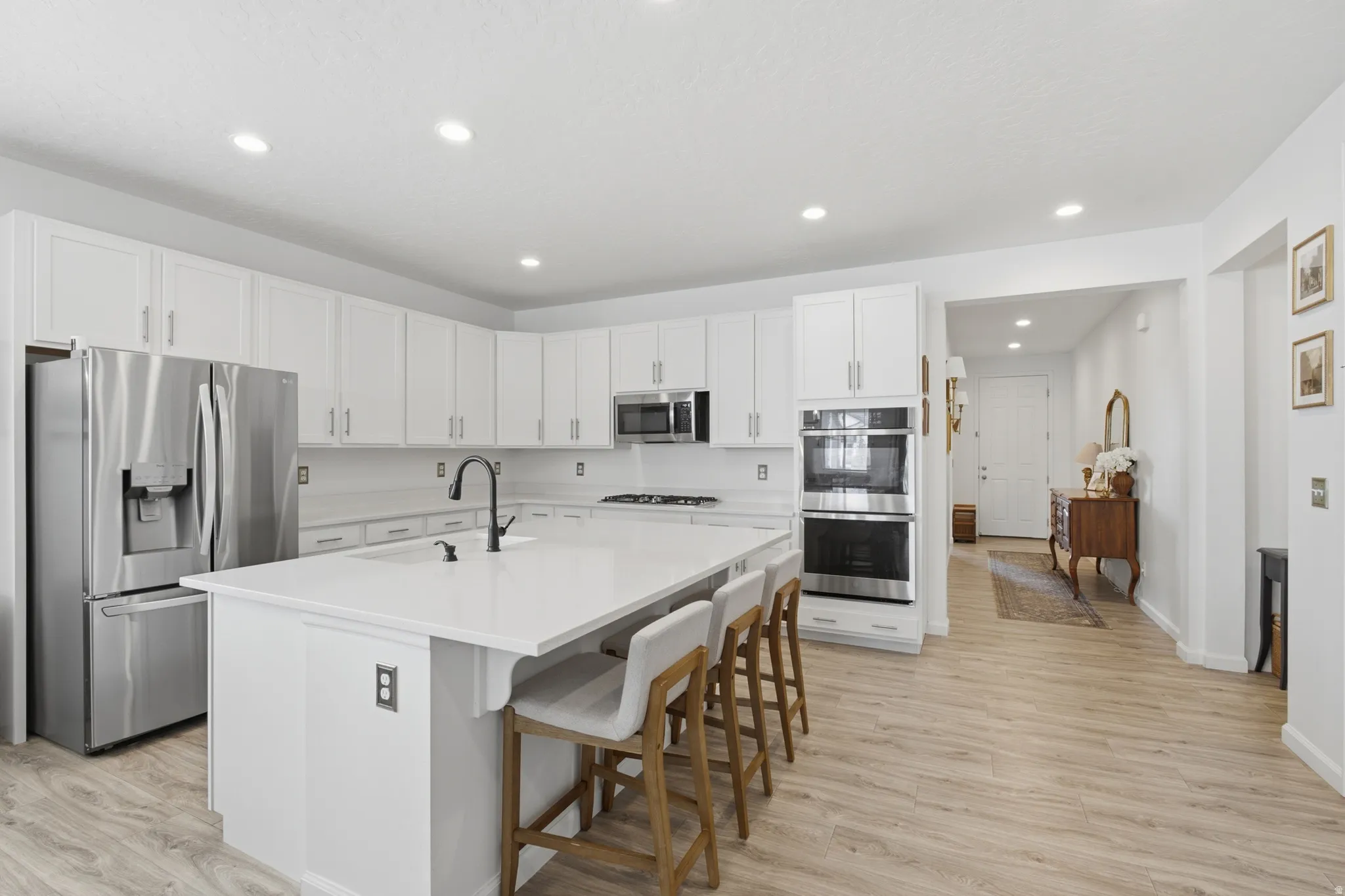 Bright kitchen with white cabinetry and stainless steel appliances
