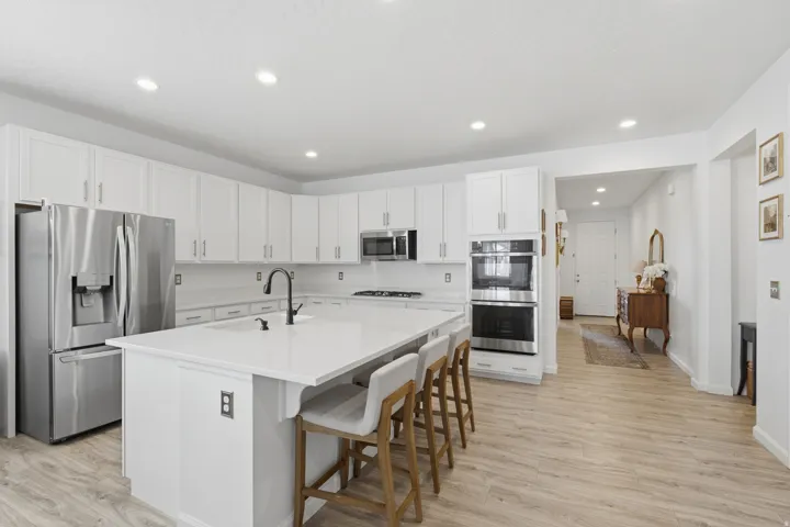 Bright kitchen with white cabinetry and stainless steel appliances