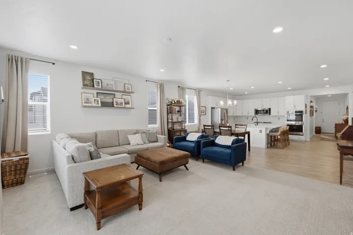 Spacious living area with recessed lighting and a carpeted floor