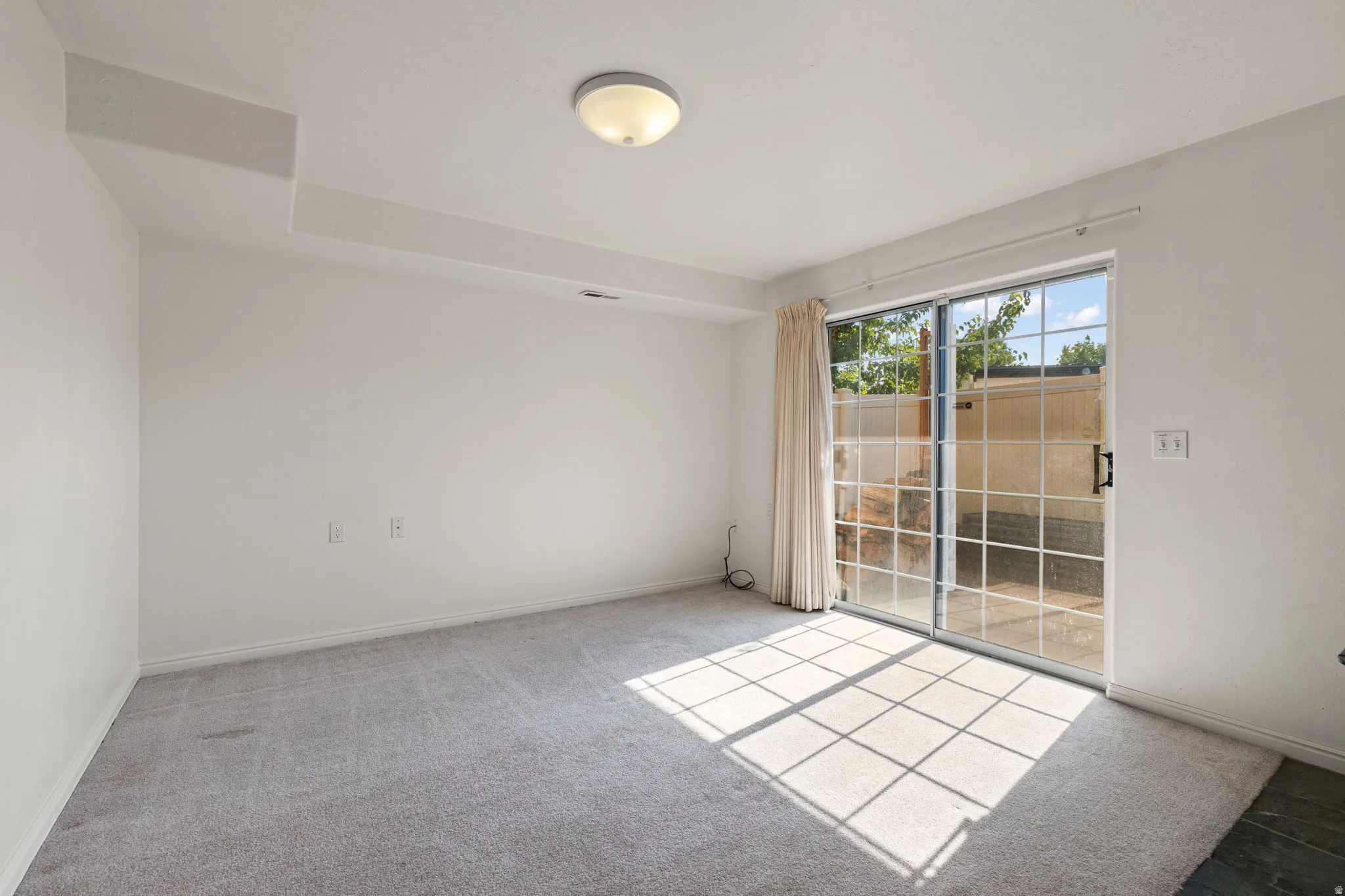 Wall-to-wall carpeting, recessed ceiling features, and a sliding glass door