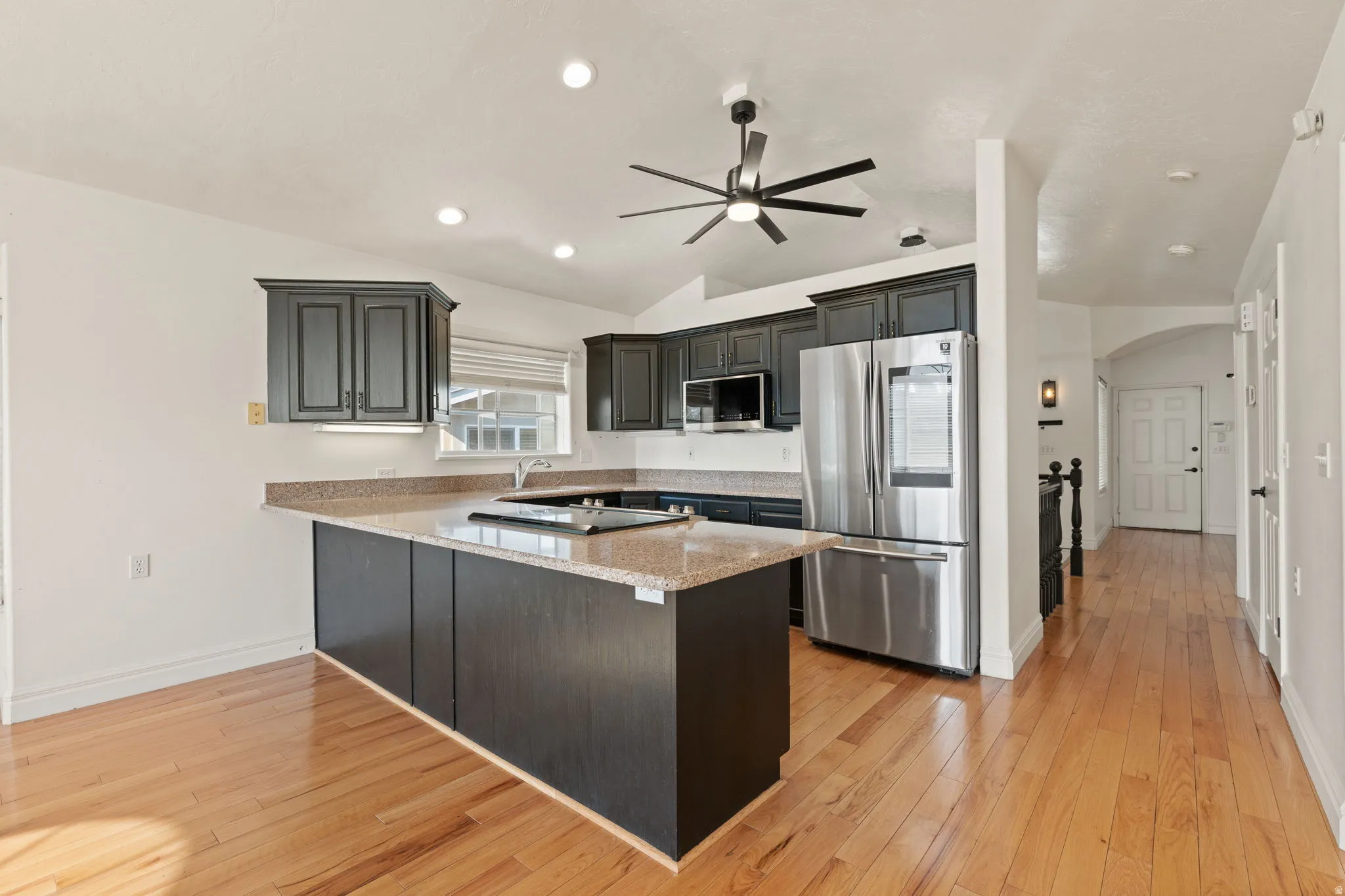 Kitchen featuring dark wood cabinetry, light-toned countertops, and stainless steel appliances