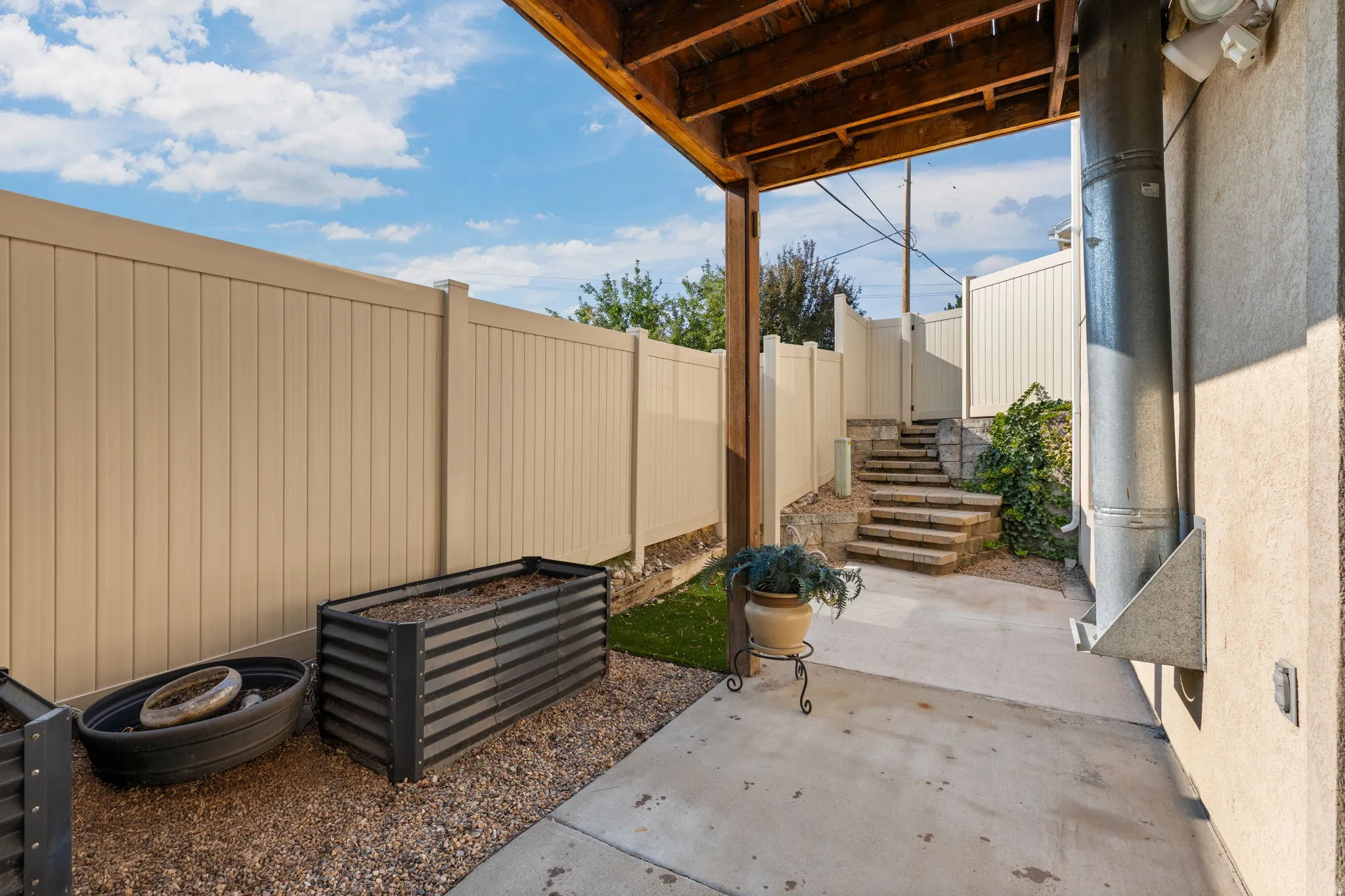 Patio with concrete flooring, under-deck ceiling, and gravel ground cover