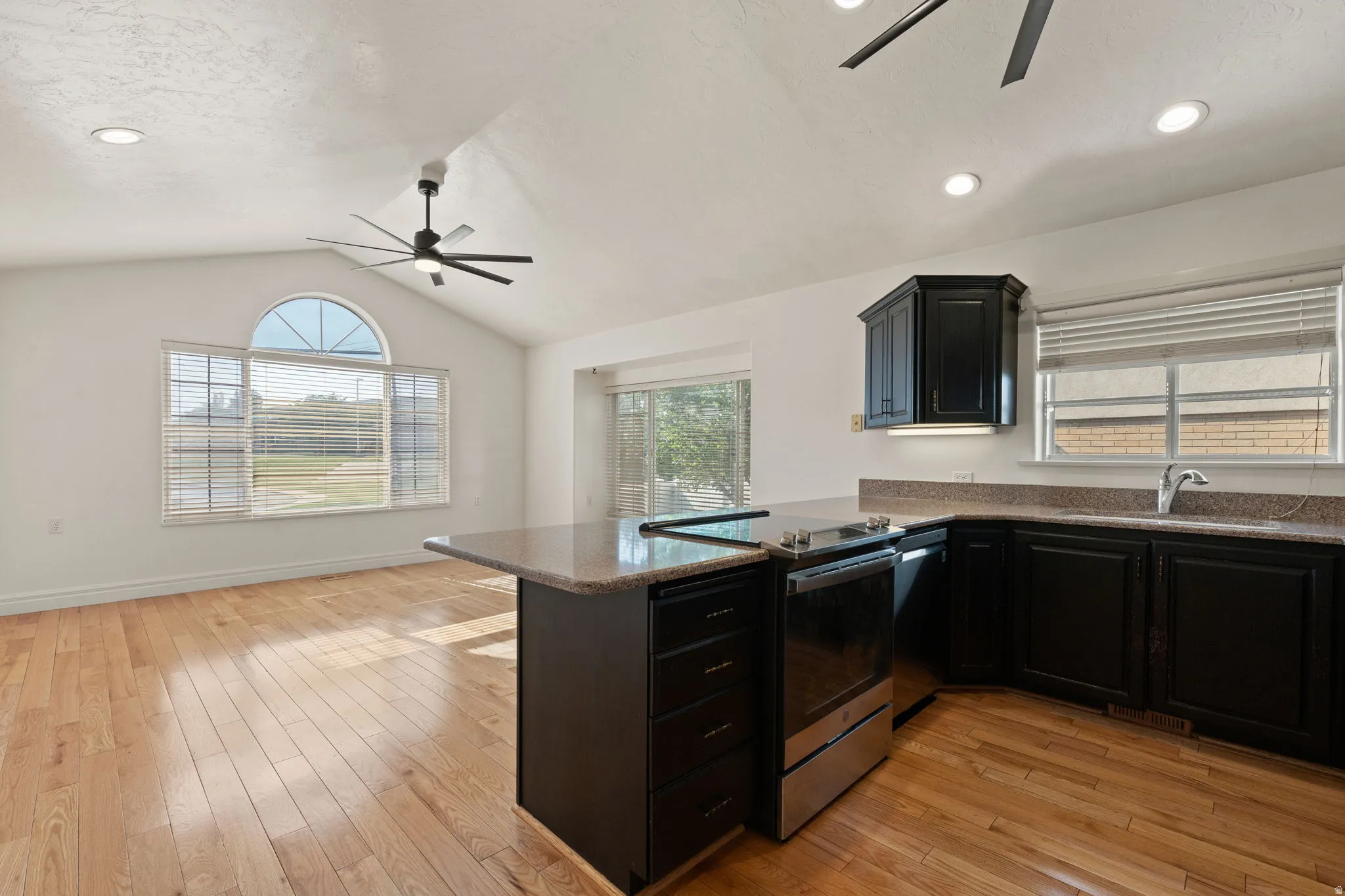 Vaulted ceiling with recessed lighting and a ceiling fan