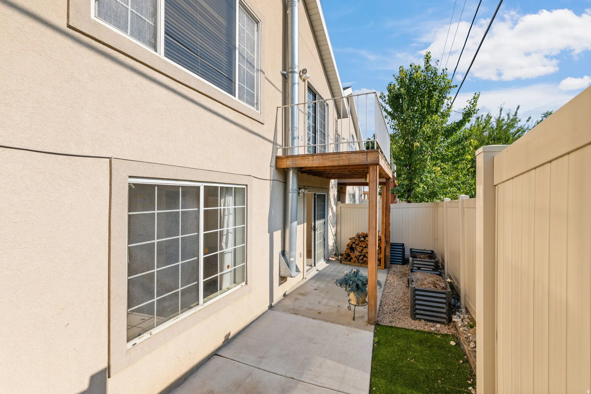 Private patio area featuring a concrete surface, artificial turf, and a wood privacy fence