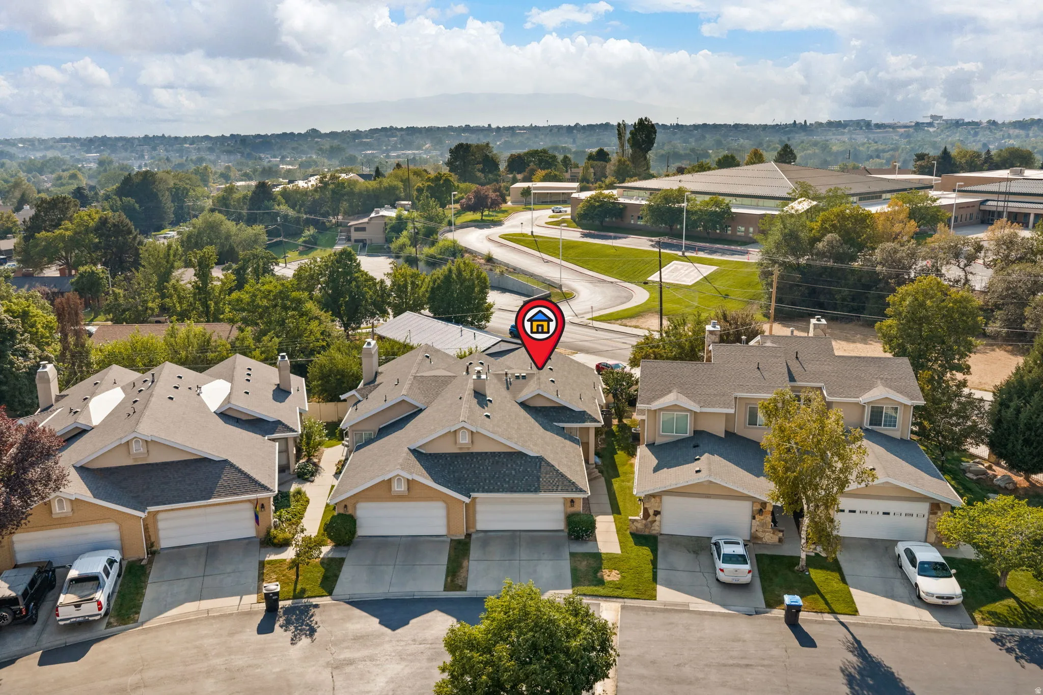 Multi-level property with an attached two-car garage, pitched roof, and mature landscaping