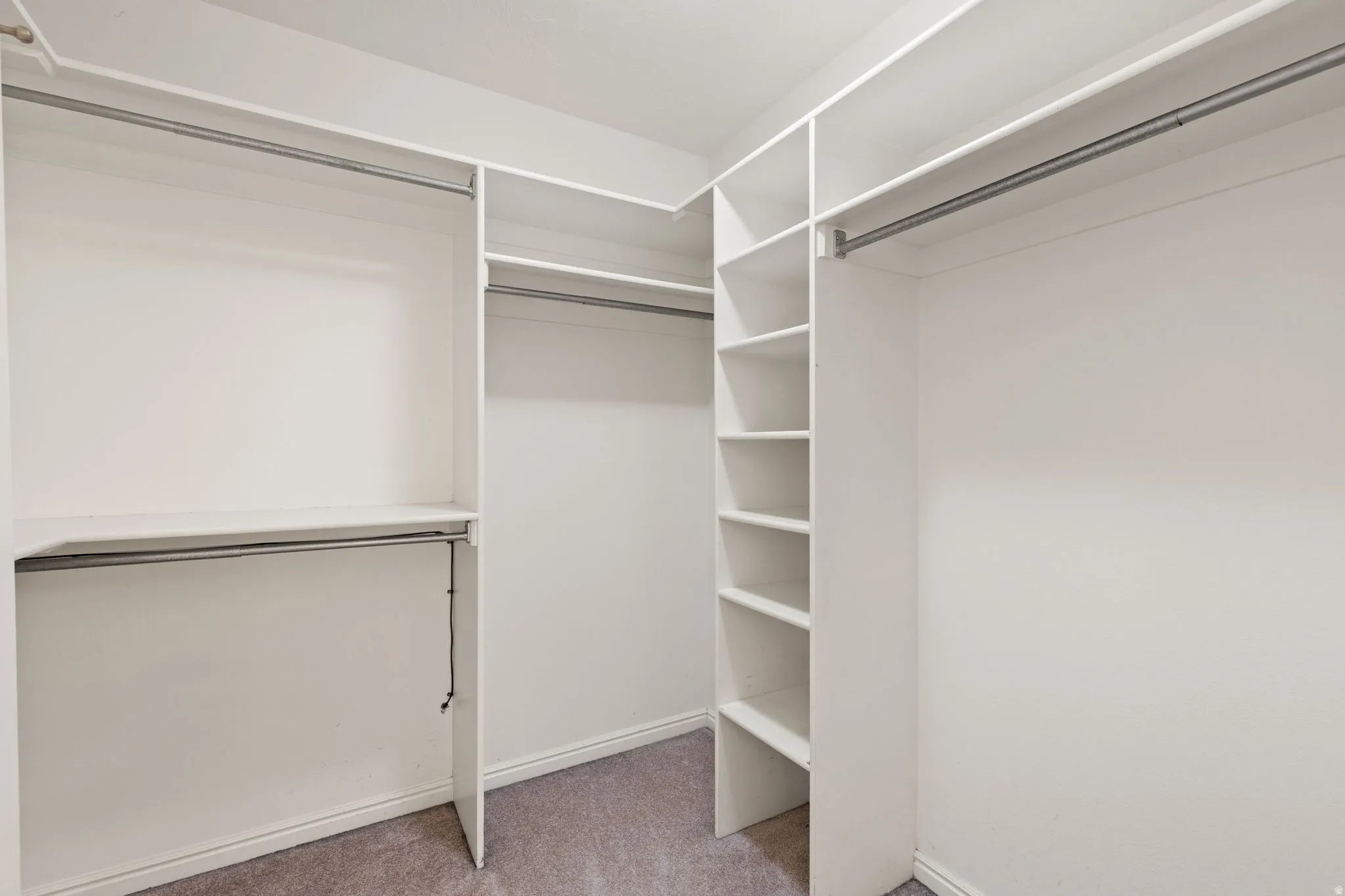 Built-in closet organization system with multiple hanging rods and shelving