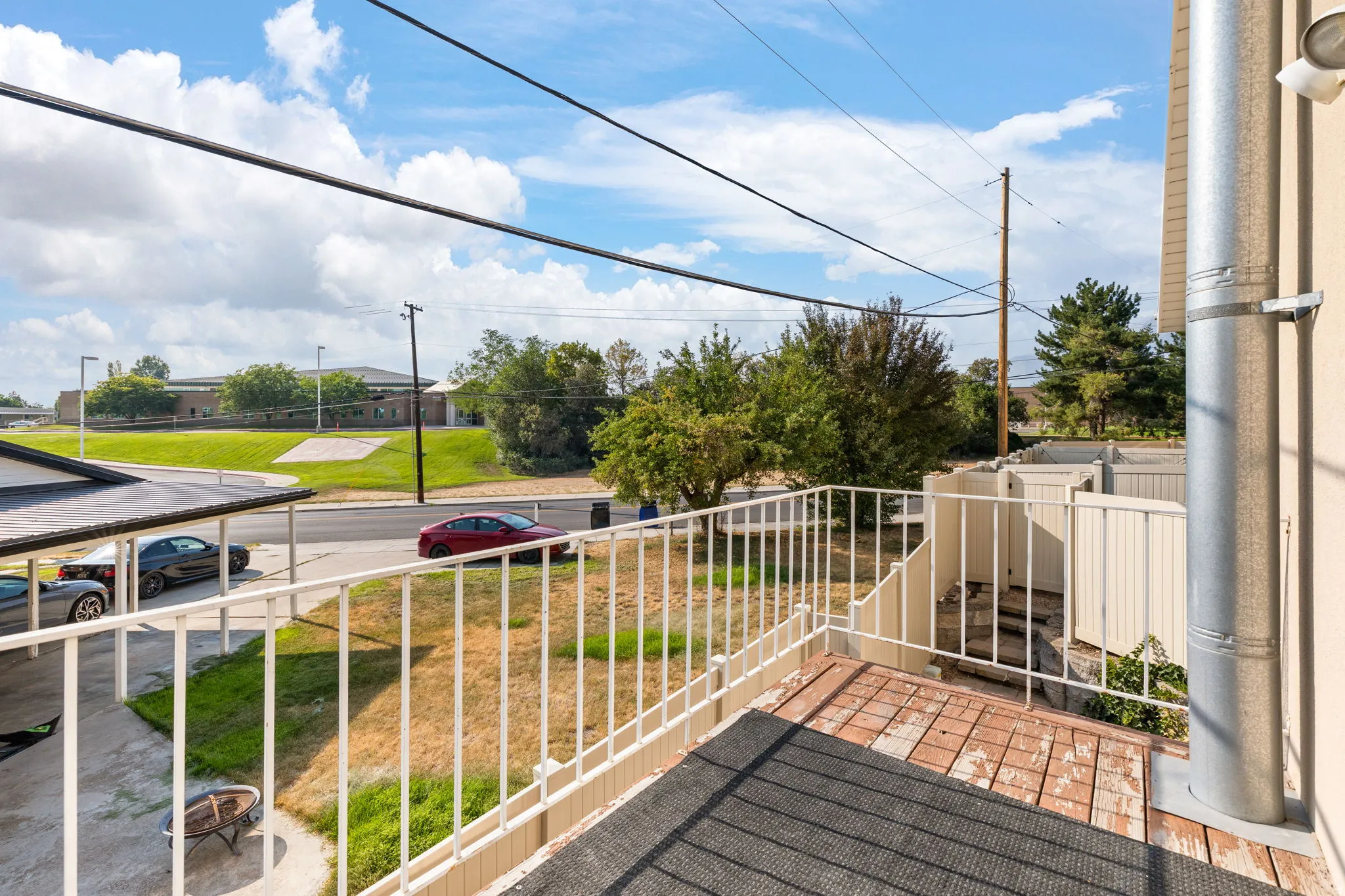 Balcony with white metal railing and brick-patterned flooring