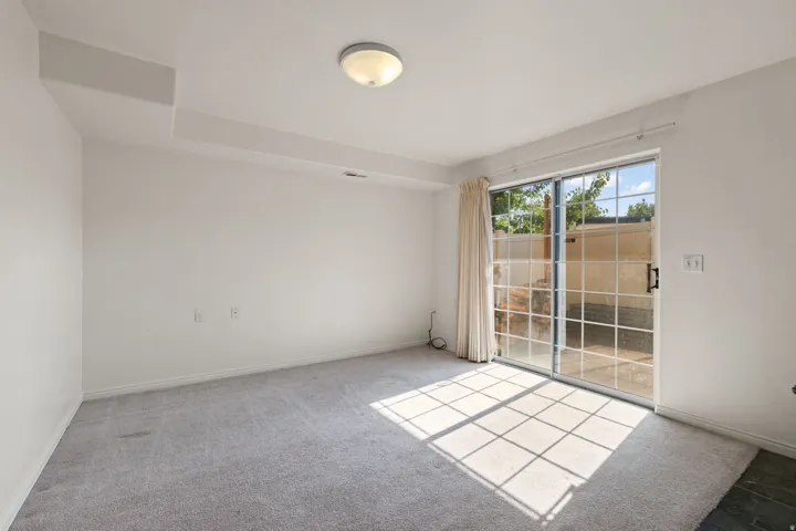 Wall-to-wall carpeting, recessed ceiling features, and a sliding glass door