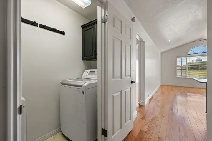 Laundry area with built-in cabinetry and coat rack