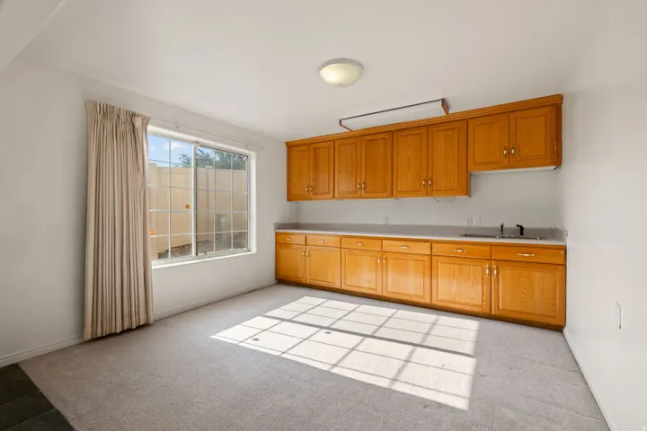 Built-in cabinetry with wood-finish doors, integrated sink, and overhead lighting