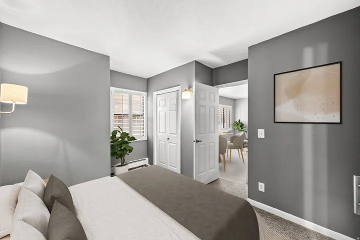 Carpeted flooring, white interior doors, window with white plantation shutters, built-in wall sconce, and neutral wall tones