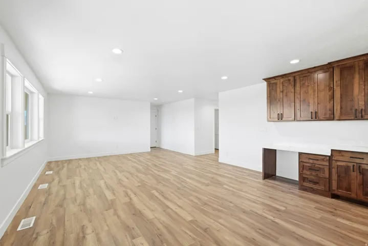 Recessed lighting, wood-finish flooring, multiple windows, built-in cabinetry, and integrated desk space