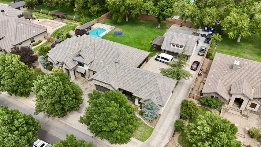 Expansive property featuring multiple structures, a swimming pool, and mature trees