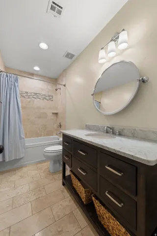 Bathroom featuring a dark wood vanity with a white stone countertop, an undermount sink, and a chrome faucet