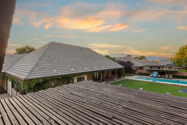 Expansive backyard featuring a rectangular swimming pool, a large grassy area, and a mature tree