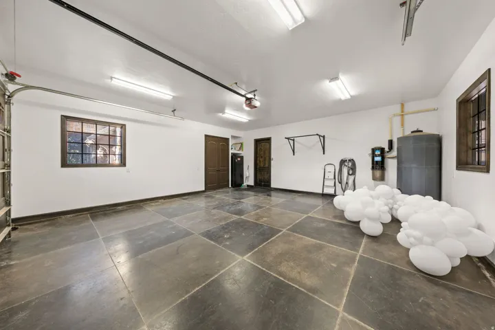 Spacious garage featuring large square floor tiles and bright overhead lighting