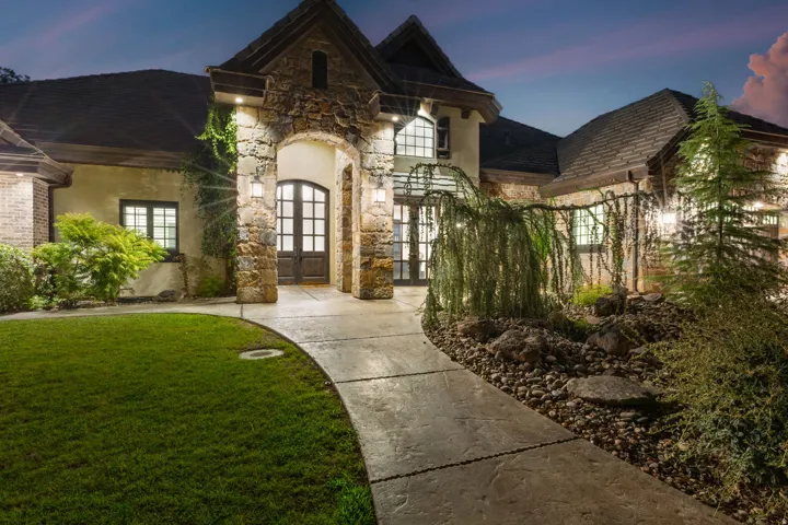Stone-clad arched entryway with double wooden doors and transom windows