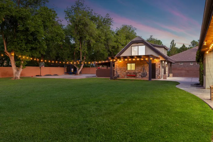 Expansive lawn with mature trees and string lighting