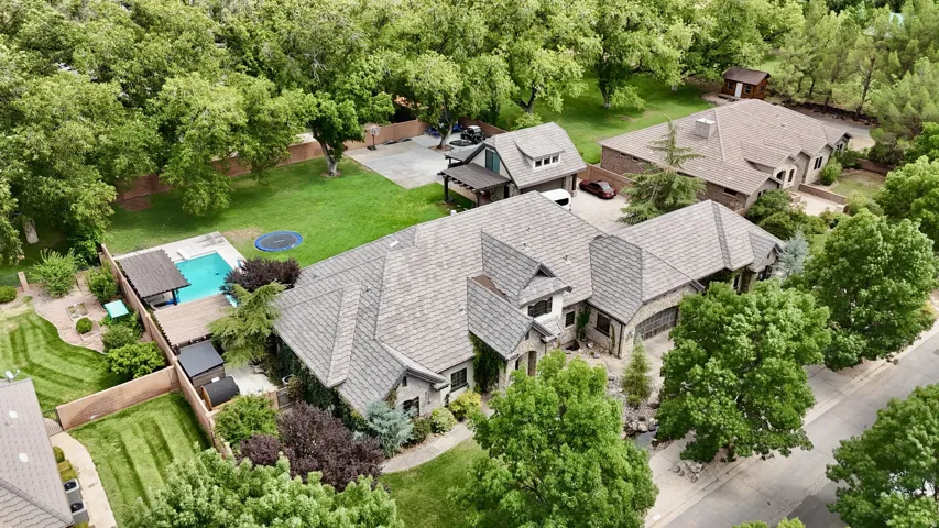 Sprawling estate showcasing multiple structures set on manicured grounds with mature landscaping