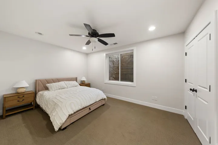 Neutral-toned room featuring a window, recessed lighting, a ceiling fan, and double-door closet